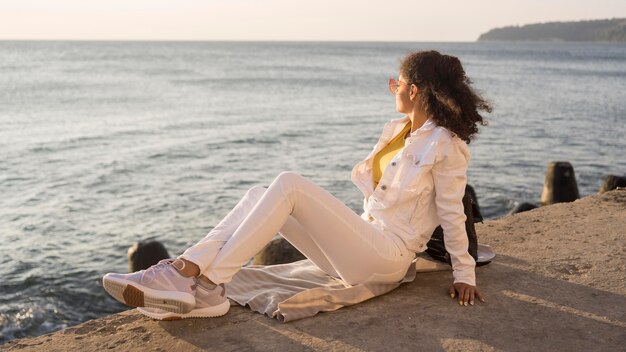 Foto completa de mulher posando à beira-mar