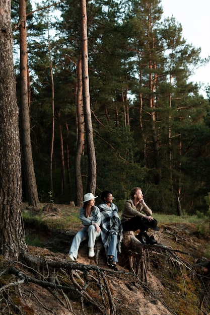 Foto completa de pessoas felizes sentadas na floresta