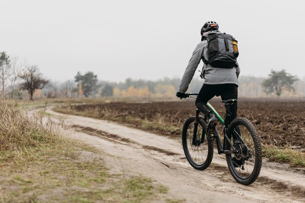 Foto completa de um homem andando de bicicleta