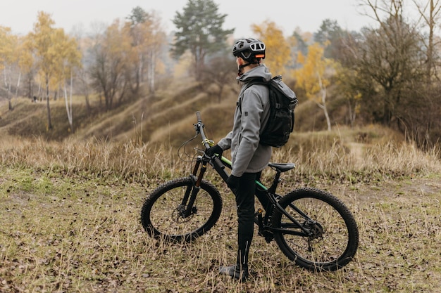 Foto completa de um homem andando de bicicleta