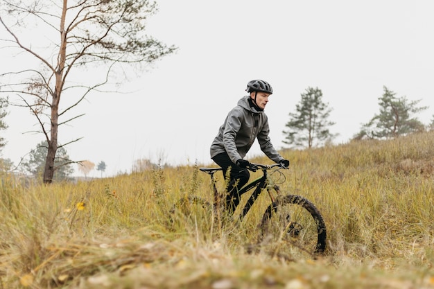 Foto completa de um homem andando de bicicleta