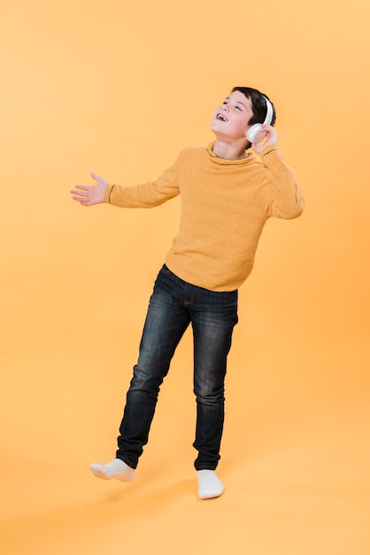Foto completa do garoto ouvindo música com fones de ouvido