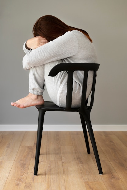 Foto grátis foto completa mulher deprimida sentada na cadeira