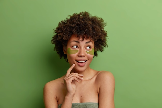 Foto grátis foto da cabeça de uma mulher sonhadora e pensativa e saudável com cabelo afro que gosta de procedimentos de cuidados com a pele