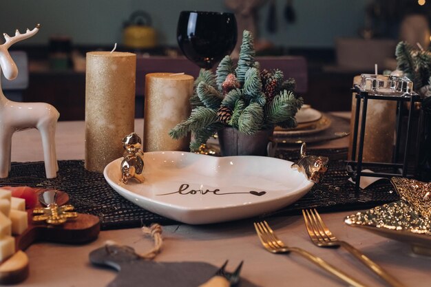 Foto da decoração da mesa de Natal com louças festivas com velas. Conceito de véspera de ano novo