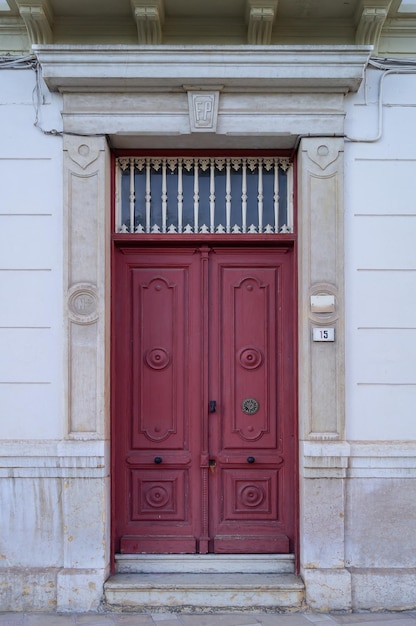 Foto da porta de madeira vermelha antiga em um edifício clássico
