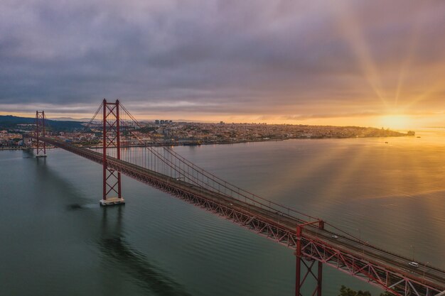 Foto da vista aérea de uma ponte pênsil em Portugal durante um belo pôr do sol