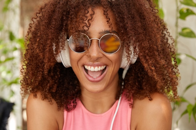 Foto de adolescente alegre e elegante com corte de cabelo afro