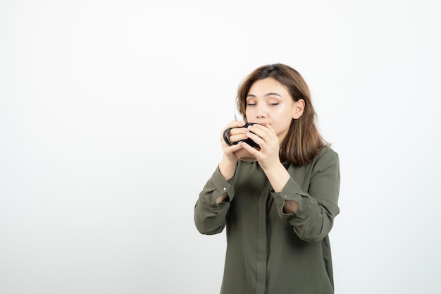 Foto de adorável jovem bebendo xícara de café quente. foto de alta qualidade