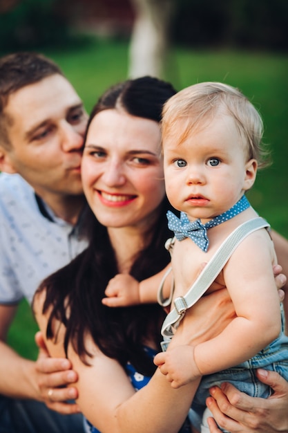 Foto de alegre mãe caucasiana, pai e filho se divertindo juntos e sorrindo no jardim