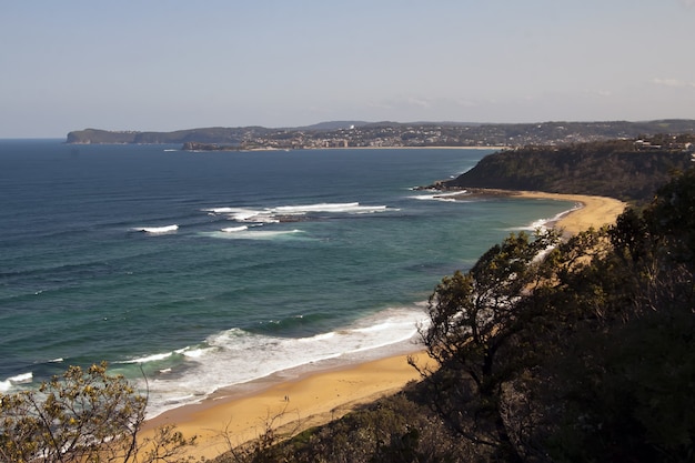 Foto de alto ângulo da costa do oceano com uma pequena praia de areia