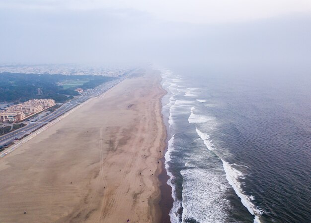 Foto de alto ângulo das ondas do oceano encontrando a costa