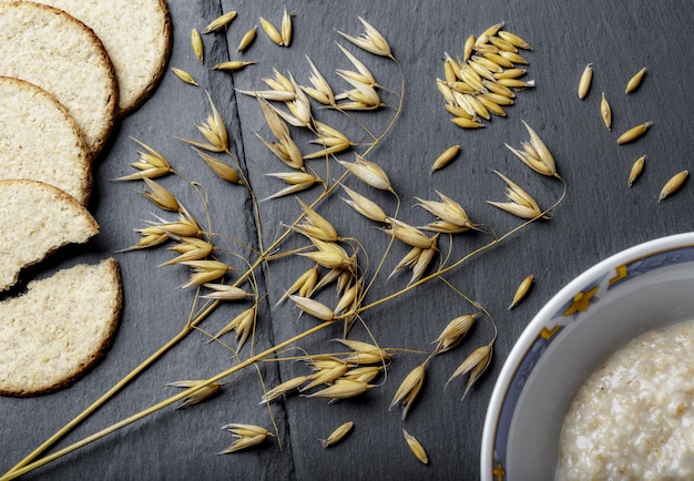 Foto grátis foto de alto ângulo de ramos de trigo, pão fresco e mingau em uma superfície cinza