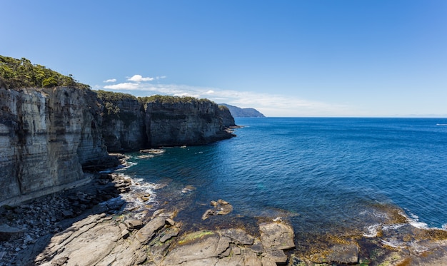 Foto de alto ângulo de tirar o fôlego dos penhascos perto da água pura de Eaglehawk Neck na Austrália