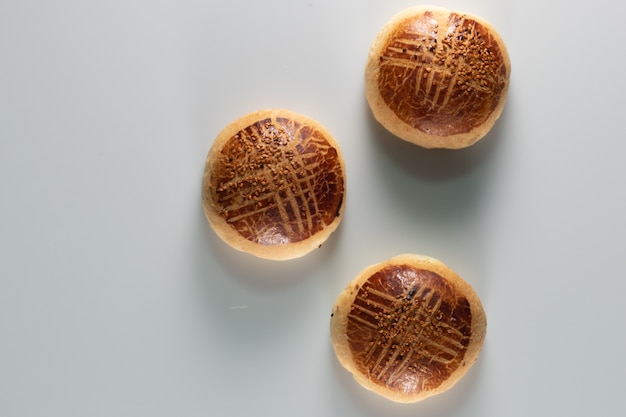 Foto de alto ângulo de três pães doces recém-assados em uma superfície branca