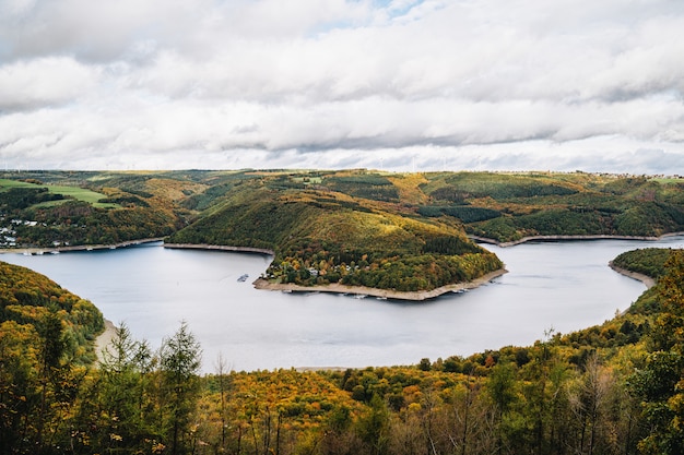 Foto grátis foto de alto ângulo de um belo lago rodeado por colinas no outono sob o céu nublado