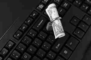Foto grátis foto de alto ângulo de um cadeado em torno de uma nota de um dólar em um laptop preto