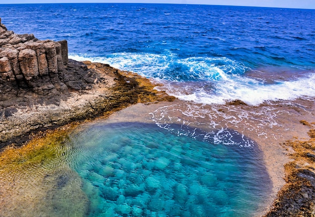 Foto de alto ângulo de um lindo mar cercado por formações rochosas nas Ilhas Canárias, Espanha