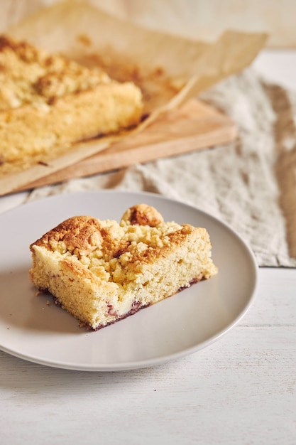 Foto de alto ângulo de um pedaço do delicioso bolo de folha de Jerry Crumble em uma mesa de madeira branca