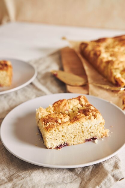 Foto de alto ângulo de um pedaço do delicioso bolo de folha de Jerry Crumble em uma mesa de madeira branca