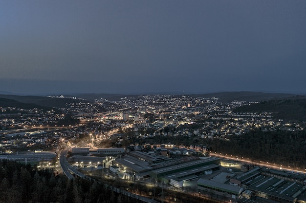 Foto de alto ângulo de uma bela cidade cercada por colinas sob o céu noturno