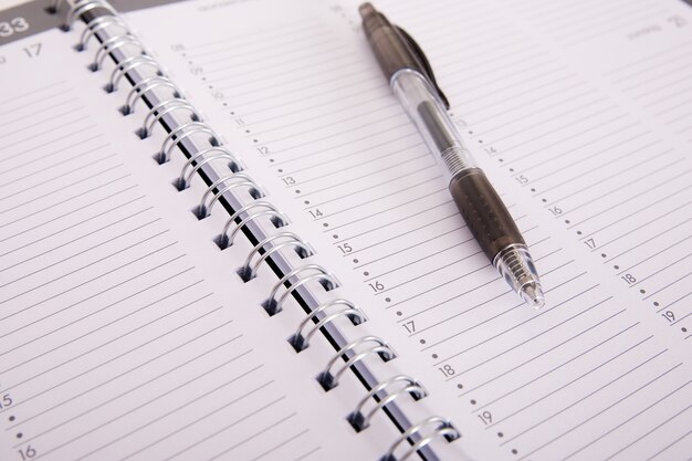 Foto de alto ângulo de uma caneta em um caderno aberto