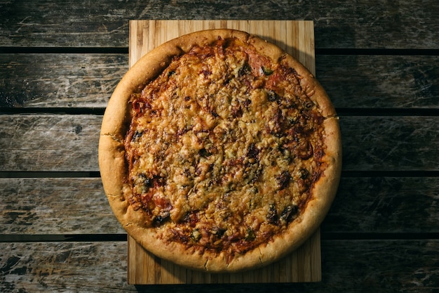 Foto de alto ângulo de uma pizza recém-assada em uma superfície de madeira