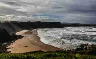 Foto grátis foto de alto ângulo de uma praia rochosa cercada por falésias sob um céu nublado