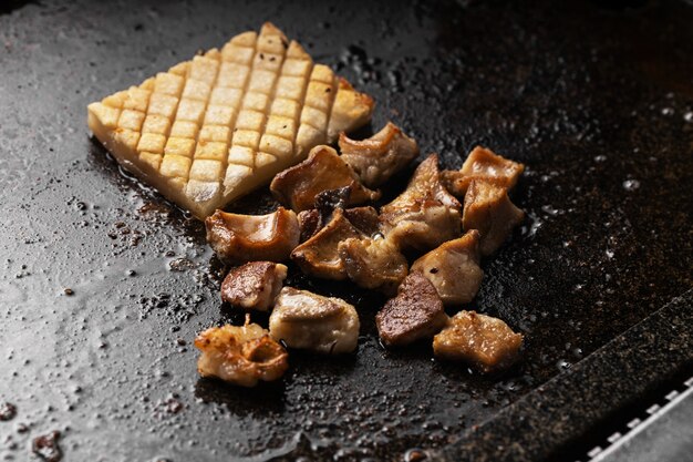 Foto de ângulo alto de deliciosa carne frita e batata em uma bandeja preta