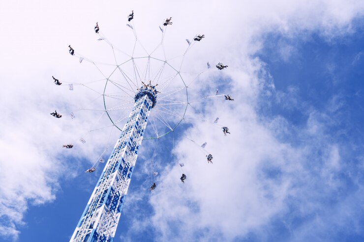 Foto grátis foto de baixo ângulo de um carrossel circular girando sob um céu cheio de nuvens