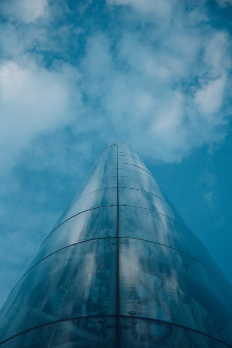 Foto grátis foto de baixo ângulo de uma torre em oslo, noruega, refletindo o céu azul nublado