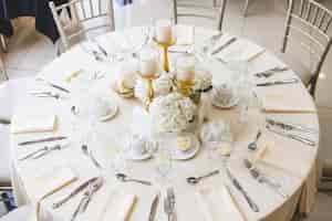 Foto grátis foto de buquês de flores brancas e velas em candelabros de ouro em uma mesa de casamento