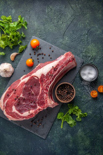 Foto de carne crua de fatia de carne fresca de vista superior com pimenta e verduras em fundo escuro farinha de frango comida animal açougueiro