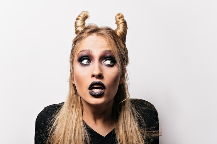 Foto grátis foto de close-up de bruxa bonita chocada. mulher loira interessada posando no carnaval de halloween.