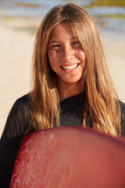 Foto grátis foto de close-up de uma jovem surfista talentosa que gosta de windsurf e carrega a prancha