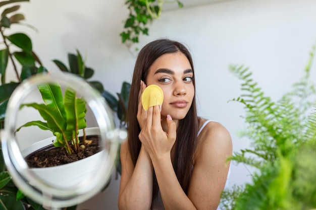 Foto de close up na cabeça de uma bela mulher agradável aplicando massagem facial após o banho.