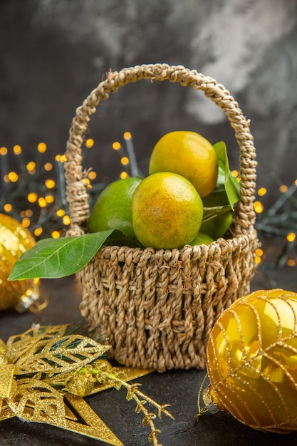 Foto de cor de fundo escuro com maçãs verdes frescas com tangerinas e frutas do feriado de natal Vista frontal