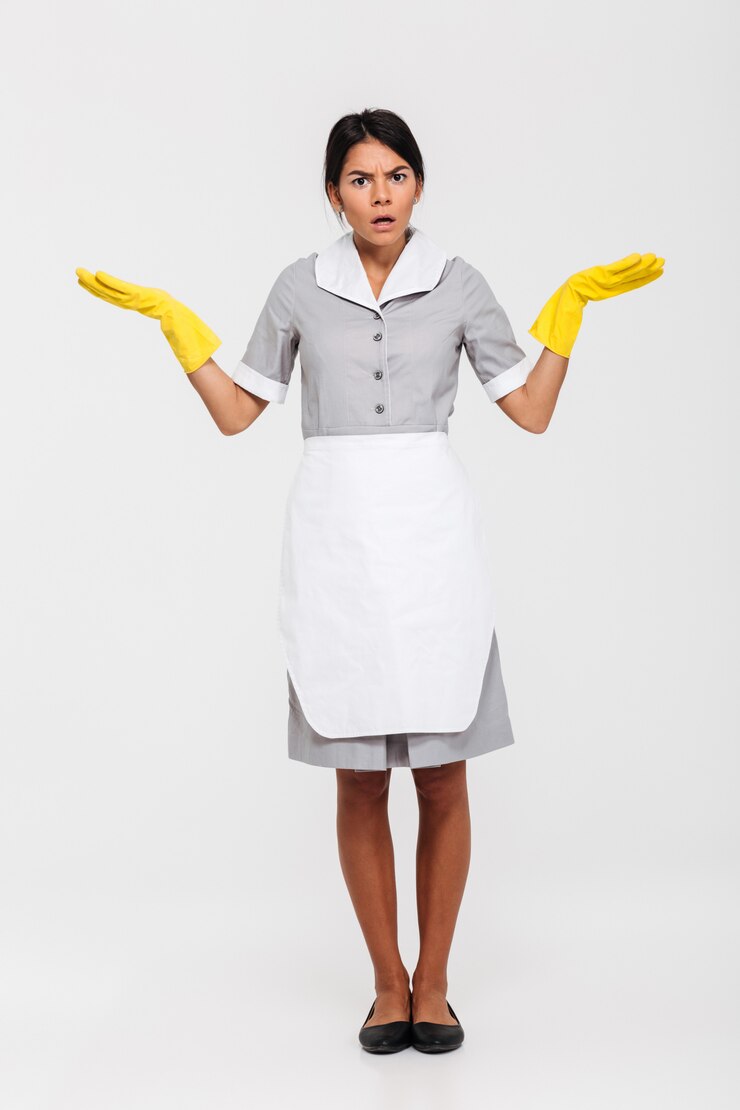 Foto grátis foto de corpo inteiro de empregada surpresa em uniforme cinza e luvas de borracha amarela em pé com as palmas das mãos abertas