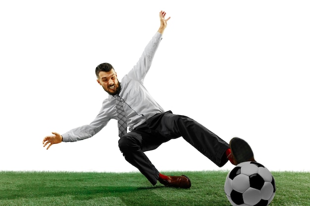 Foto de corpo inteiro de um jovem empresário jogando futebol, isolado na parede branca