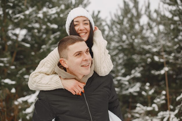 Foto de estilo de vida de casal caminhando em um bosque nevado