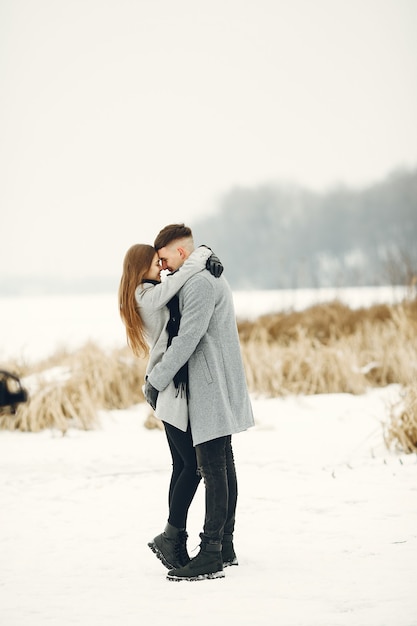 Foto de estilo de vida de casal caminhando no bosque nevado. Pessoas passando as férias de inverno ao ar livre.