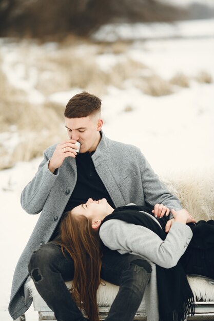 Foto de estilo de vida de casal no bosque nevado. Pessoas passando as férias de inverno ao ar livre.