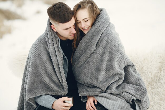 Foto de estilo de vida de casal no bosque nevado. Pessoas passando as férias de inverno ao ar livre.