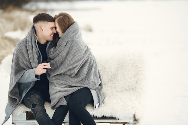 Foto grátis foto de estilo de vida de casal no bosque nevado. pessoas passando as férias de inverno ao ar livre.