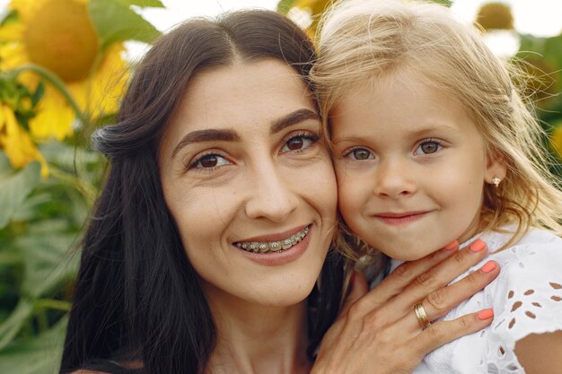 Foto de família feliz. Mãe e filha. Família unida no campo de girassol.