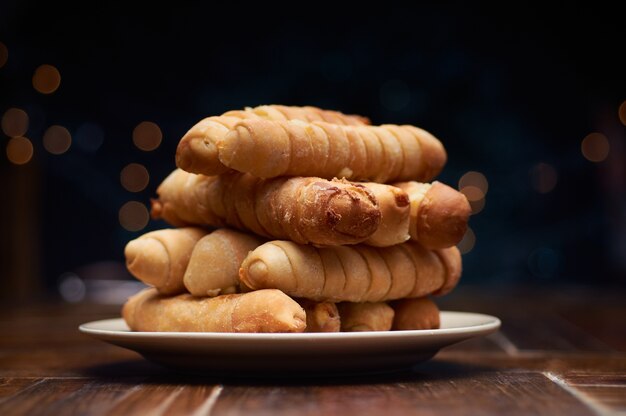 Foto de foco seletivo de corndogs em um prato com um fundo escuro