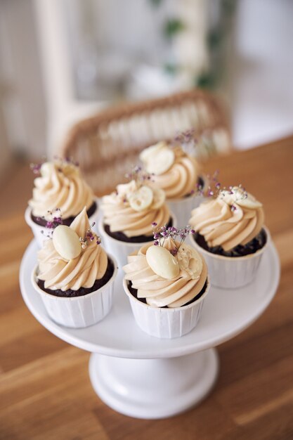 Foto de foco seletivo de deliciosos bolinhos de chocolate com cobertura de creme branco