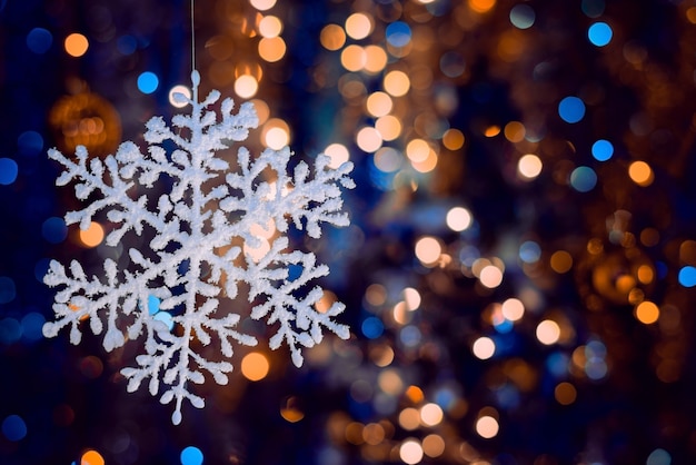 Foto de foco seletivo de um floco de neve decorativo em fundo desfocado bokeh