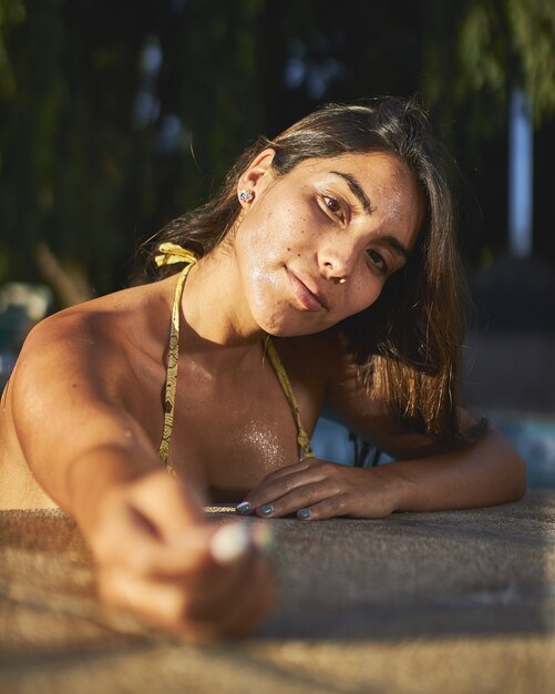 Foto de foco seletivo de uma atraente mulher nativa americana posando em uma piscina