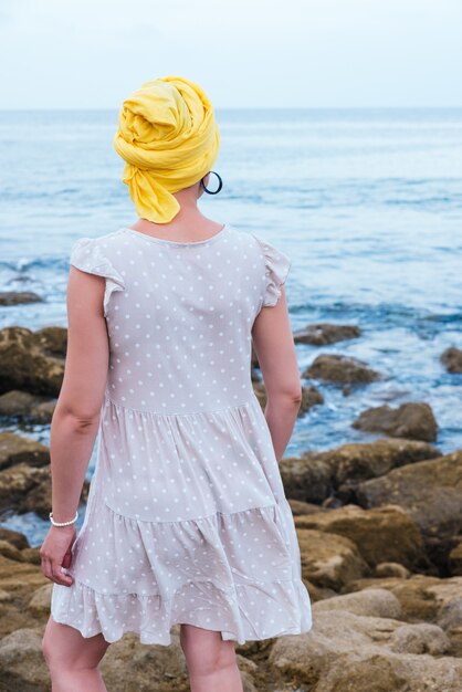 Foto de foco seletivo de uma jovem relaxando à beira-mar